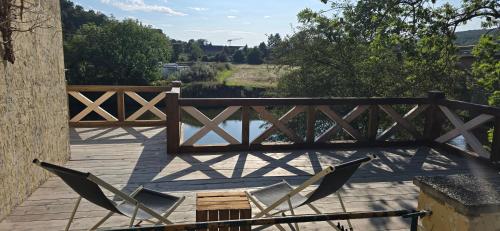 a wooden deck with chairs and a wooden bridge at Altes Saale Fährhaus in Naumburg