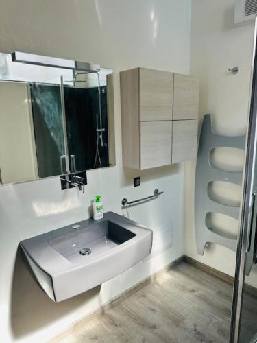 a bathroom with a sink and a mirror at Direttamente Al Lago Apartments in Marone