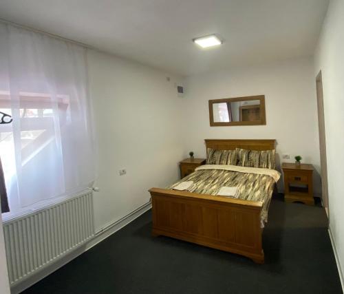 ein Schlafzimmer mit einem Bett und einem Spiegel an der Wand in der Unterkunft Casa Rizea in Râmnicu Vâlcea