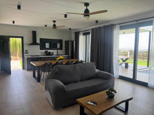 ein Wohnzimmer mit Couch und Tisch und eine Küche in der Unterkunft Villas de lujo con Chimenea y Vistas Panorámicas a la Sierra de Cazorla in Pozo Alcón