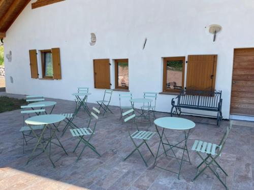 a room with tables and chairs and a bench at Agriturismo Maso San Valentino in San Michele allʼAdige