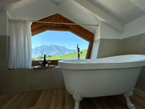a white bath tub in a bathroom with a window at Agriturismo Maso San Valentino in San Michele allʼAdige