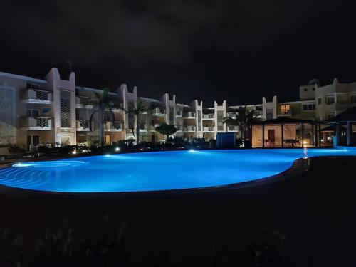 an empty swimming pool at night in front of a building at Marialva Tropical T1 in Santa Maria
