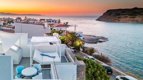 a house with a view of the ocean at sunset at New Seaview Villa Moments with Rooftop Hot Tub, 50m from the Beach in Mochlos