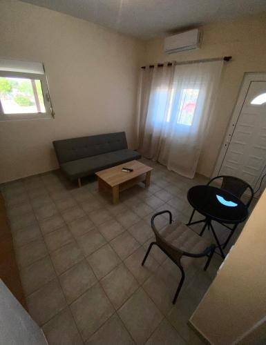 a living room with a couch and a table and chairs at Vira Apartment in Pherrai