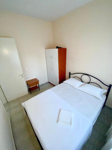 a bedroom with a white bed and a cabinet at Vira Apartment in Pherrai