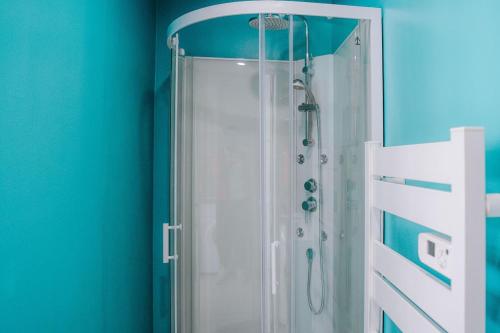 eine Dusche in einem Badezimmer mit einer blauen Wand in der Unterkunft La Maison MMM - Proche Centre & Commerces in Châteauroux