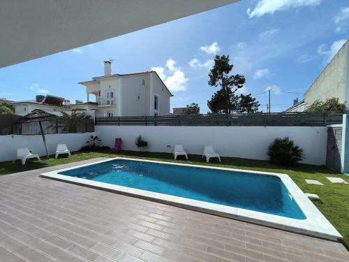 a swimming pool in the backyard of a house at Apartamento "Vila Serena Marisol" in Corroios