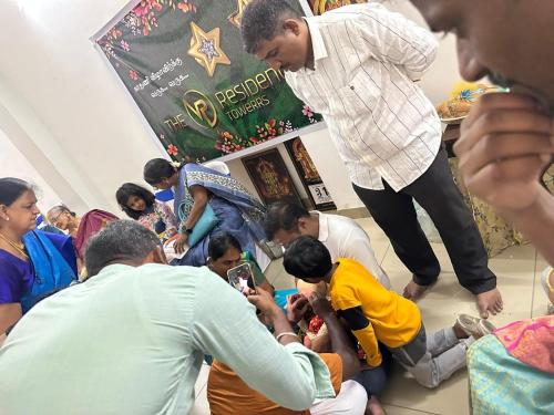 a group of people standing around in a room at The VP Residency Towerrs in Tiruttani