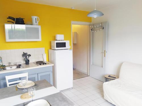 a small kitchen with a white refrigerator and a microwave at Cozy Studio Beaujolais - Porte de Lyon - Piscine&Tennis in Villefranche-sur-Saône