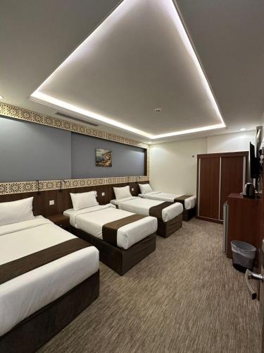 a hotel room with three beds and a tv at فندق برايت in Mecca