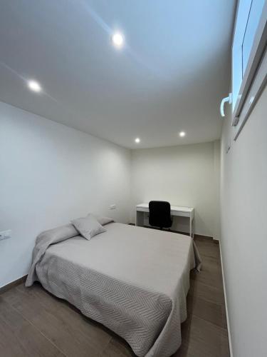 a bedroom with a bed and a desk and a chair at Loft Puerto Real in Puerto Real