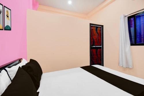 a bedroom with a white bed and a window at Hotel O Welcome Guest House in Patna