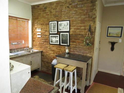 una cucina con bancone e muro di mattoni di Selah guest cottage...place to pause, breath relax a Bethulie
