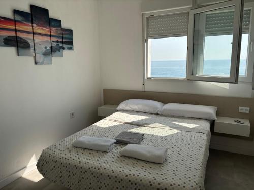 ein Schlafzimmer mit zwei Betten und zwei Fenstern in der Unterkunft Vista al mar con piscina in Faro de Cullera