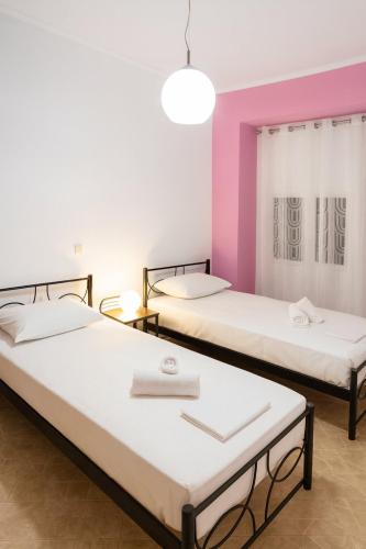 two beds in a room with pink and white at Efi's house in Análipsis