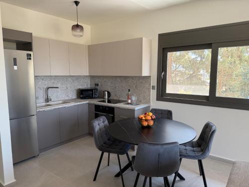 a kitchen with a table and chairs and a kitchen with a window at Poseidon 77B Luxury Residences in Loutraki