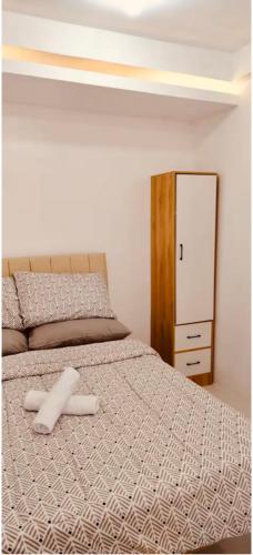 ein Bett mit zwei weißen Handtüchern darauf in der Unterkunft Svens Place in Puerto Princesa