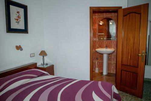 a bedroom with a bed and a sink and a mirror at Pensión San Francisco 