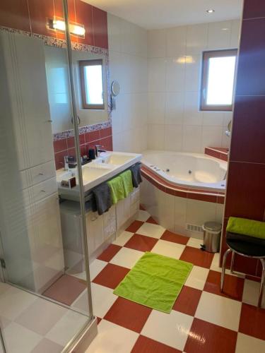a bathroom with a tub and a sink and a shower at Hotel Erlebniswelt Stocker in Schladming