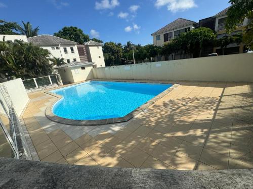 a swimming pool in the backyard of a house at L'ile aux couleurs in Les Abymes