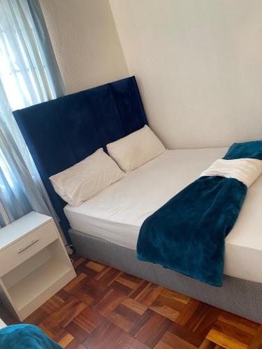 a small bed with a blue headboard in a room at two lovers in Vosburg