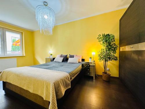 a bedroom with a large bed and a chandelier at Apartament Kryształowy - Kołobrzeg in Kołobrzeg