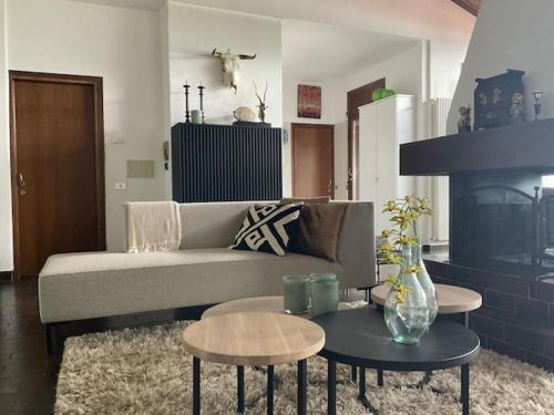 un soggiorno con divano, tavoli e camino di Villa la Grona a Menaggio