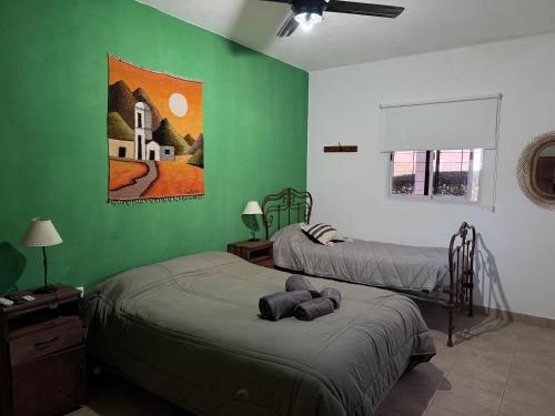 エル・ロデオにあるEl descansoの緑の壁の部屋にベッドが2つある