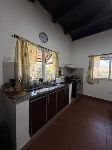 una cucina con un lavandino e un orologio a parete di El descanso a El Rodeo