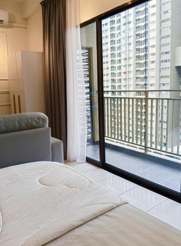 a bedroom with a bed and a large window at Studio with Rooftop Pool at Youth City Nilai by D'KAY HOMES, near USIM KLIA in Nilai