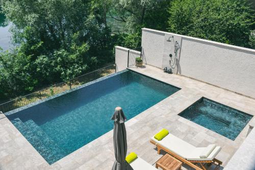 a swimming pool with two lounge chairs and a swimming pool at Villa Teja in Mostar