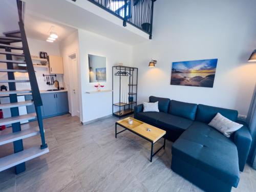 a living room with a blue couch and a table at Hideaway Thassos in Limenaria