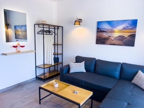 a living room with a blue couch and a table at Hideaway Thassos in Limenaria