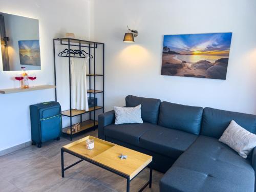 a living room with a blue couch and a table at Hideaway Thassos in Limenaria
