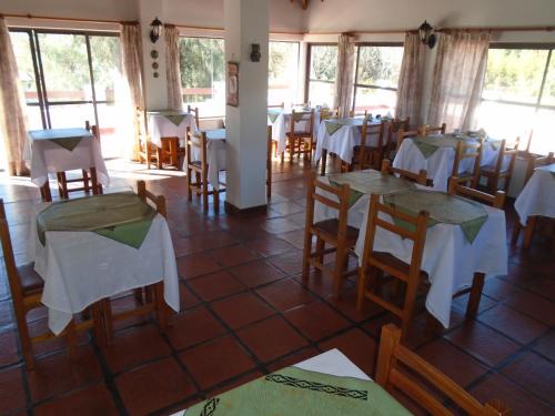 a restaurant with tables and chairs with white table cloth at Hostería de los Césares in Merlo