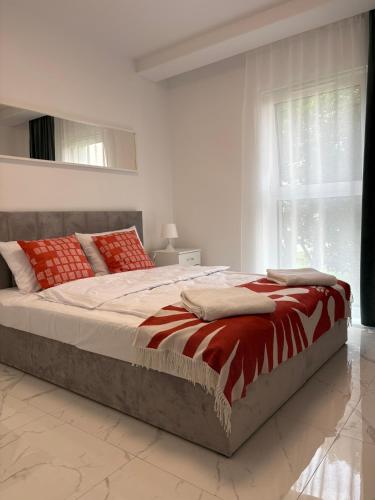 a bedroom with a large bed with red and white pillows at Aura Apartamenty in Brzeg