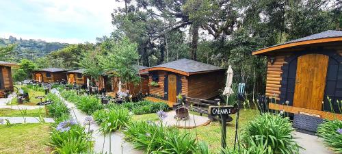 a row of wooden cabins in a resort at Pousada Chales da Mantiqueira - Campos do Jordão in Campos do Jordão