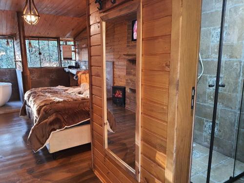 a bedroom with a bed in a wooden cabin at Pousada Chales da Mantiqueira - Campos do Jordão in Campos do Jordão