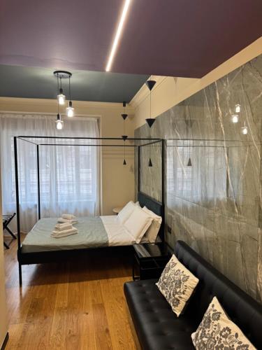 a bedroom with a bed and a couch in a room at Flat in Duomo in Milan