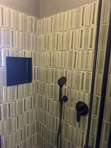a bathroom with a shower with a tv on the wall at Flat in Duomo in Milan