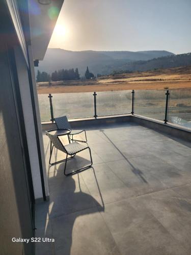 a chair sitting on a balcony looking out at the water at צימר בגליל in Qiryat Shemona