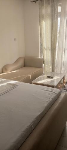 two beds in a living room with a couch at Jnjzhomes Mombasa in Mombasa