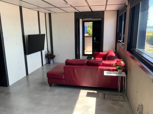a red couch in a room with a tv at Modern apartment with magnificent views in Vaudreuil-Dorion