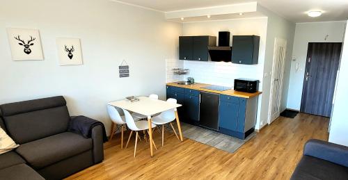 a kitchen and a living room with a couch and a table at Apartamenty Szóstka Wisła Kamienna in Wisła