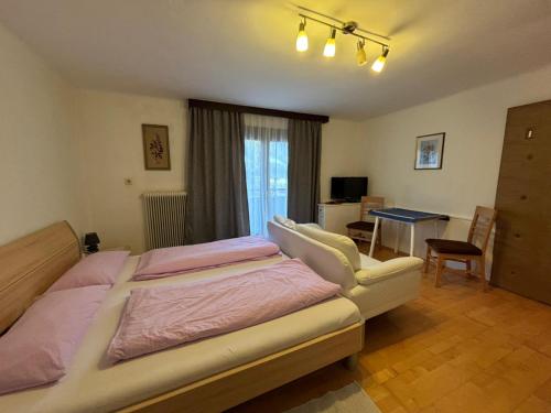 a bedroom with a bed and a desk and a table at Appartement Unterstein 1 in Niedernsill
