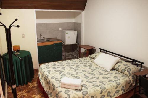 a small bedroom with a bed and a kitchen at Casa Posada Amelia in Bogotá