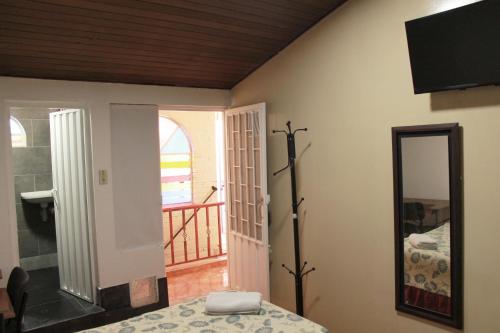 a room with a table and a mirror and a balcony at Casa Posada Amelia in Bogotá