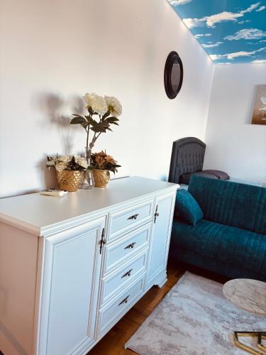 sala de estar con armario blanco y sofá azul en Apartman MM, en Sremska Mitrovica