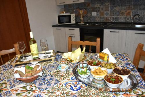 a table with dishes of food and a bottle of wine at Casa Vacanze Giorgia in Marinella di Selinunte